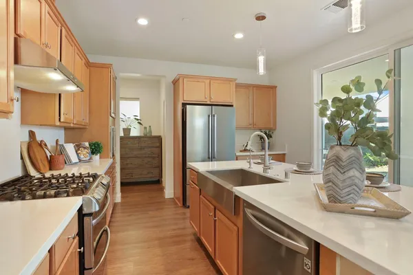 a kitchen with stainless steel appliances granite countertop a sink stove and refrigerator