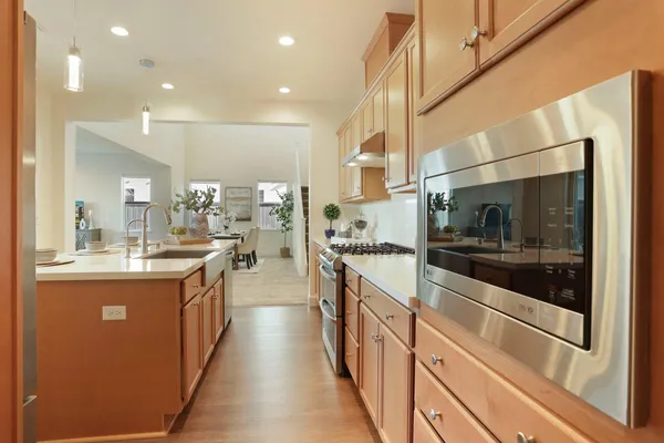 a large kitchen with stainless steel appliances kitchen island granite countertop a large counter top and a stove