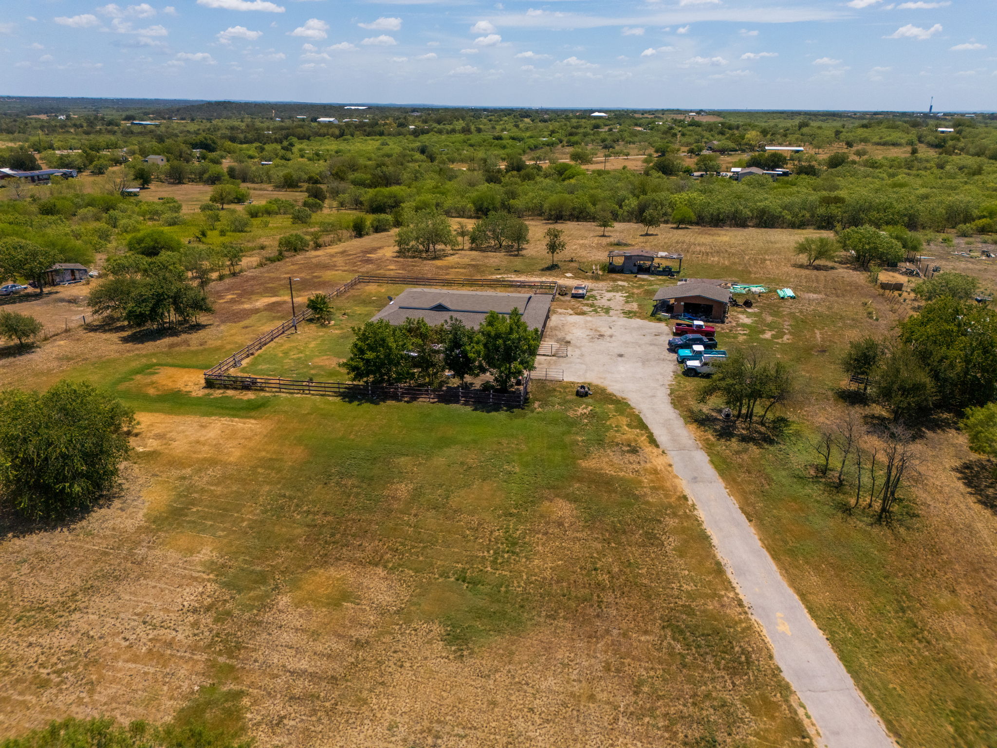 1781 Long Road Lockhart, TX 78644 - Photo 4 of 17 A long paved driveway leads to a secluded homestead surrounded by expansive acreage.