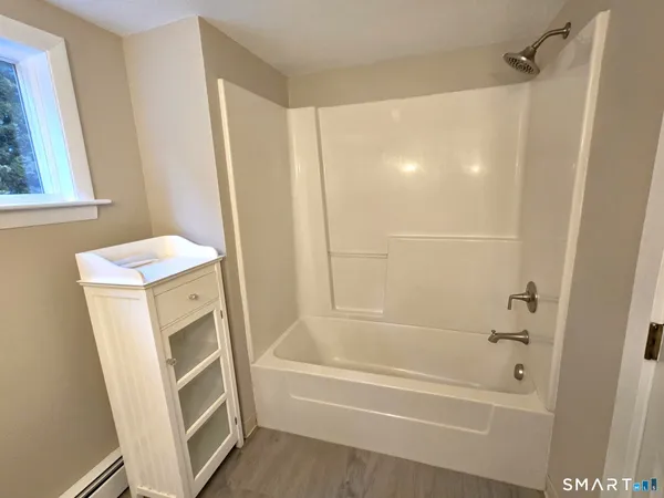 a bathroom with a tub sink and a mirror