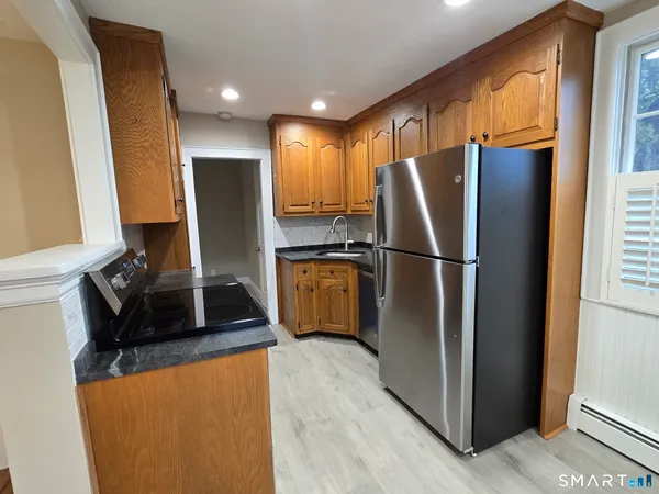 a kitchen with stainless steel appliances granite countertop a refrigerator a stove a sink and a refrigerator