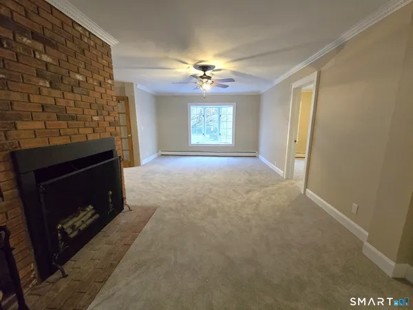 a view of empty room with a fireplace and fan