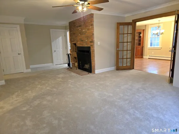 an empty room with windows and fireplace