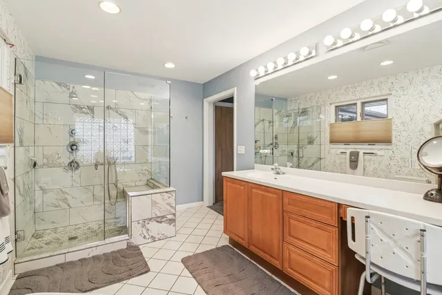 a spacious bathroom with a shower sink mirror and