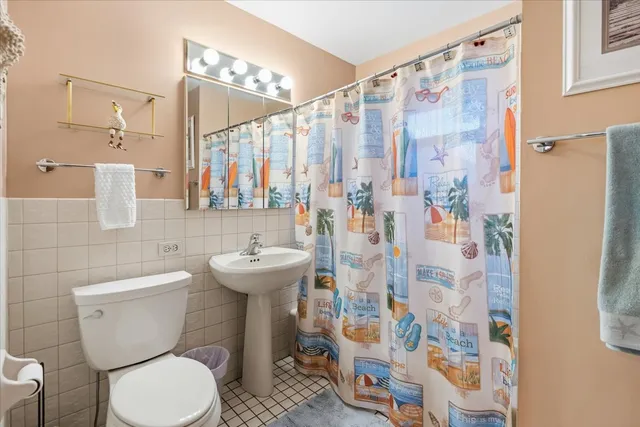 a bathroom with a toilet sink and shower curtain