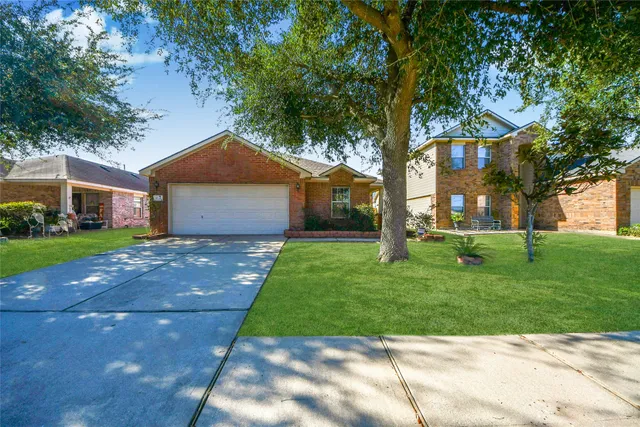a front view of a house with a garden and trees