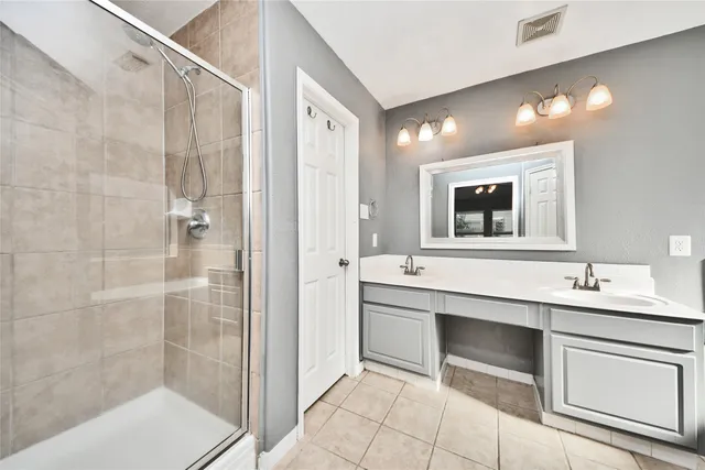 a bathroom with a double vanity sink a mirror and a shower
