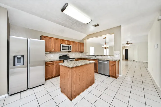 a kitchen with stainless steel appliances granite countertop a refrigerator and a sink