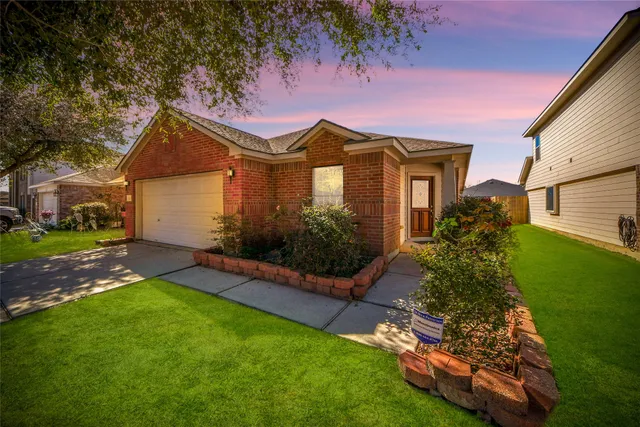 a front view of a house with a garden and yard