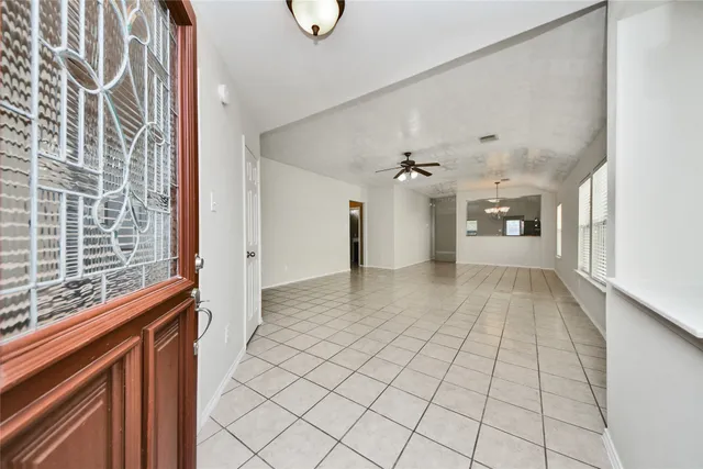 a view of a hallway with wooden floor and a chandelier