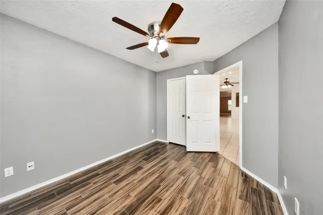 a view of wooden floor and a ceiling fan in a room