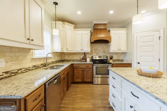 a kitchen with stainless steel appliances granite countertop a stove sink and cabinets