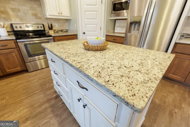 a kitchen with granite countertop a sink stove and cabinets