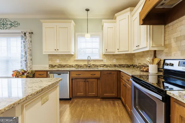 a kitchen with stainless steel appliances granite countertop a sink stove and cabinets
