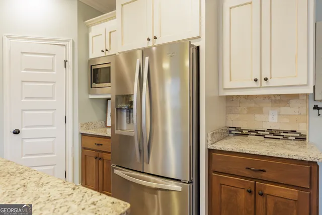 a kitchen with stainless steel appliances granite countertop a refrigerator and a stove