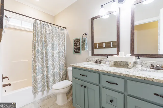 a bathroom with a granite countertop sink toilet a large mirror and shower