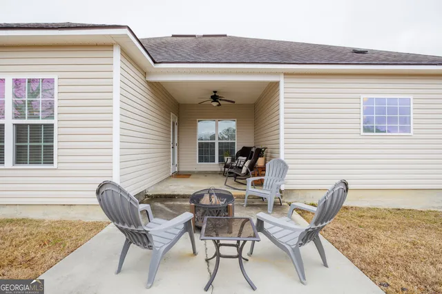 a view of a house with a backyard and sitting area