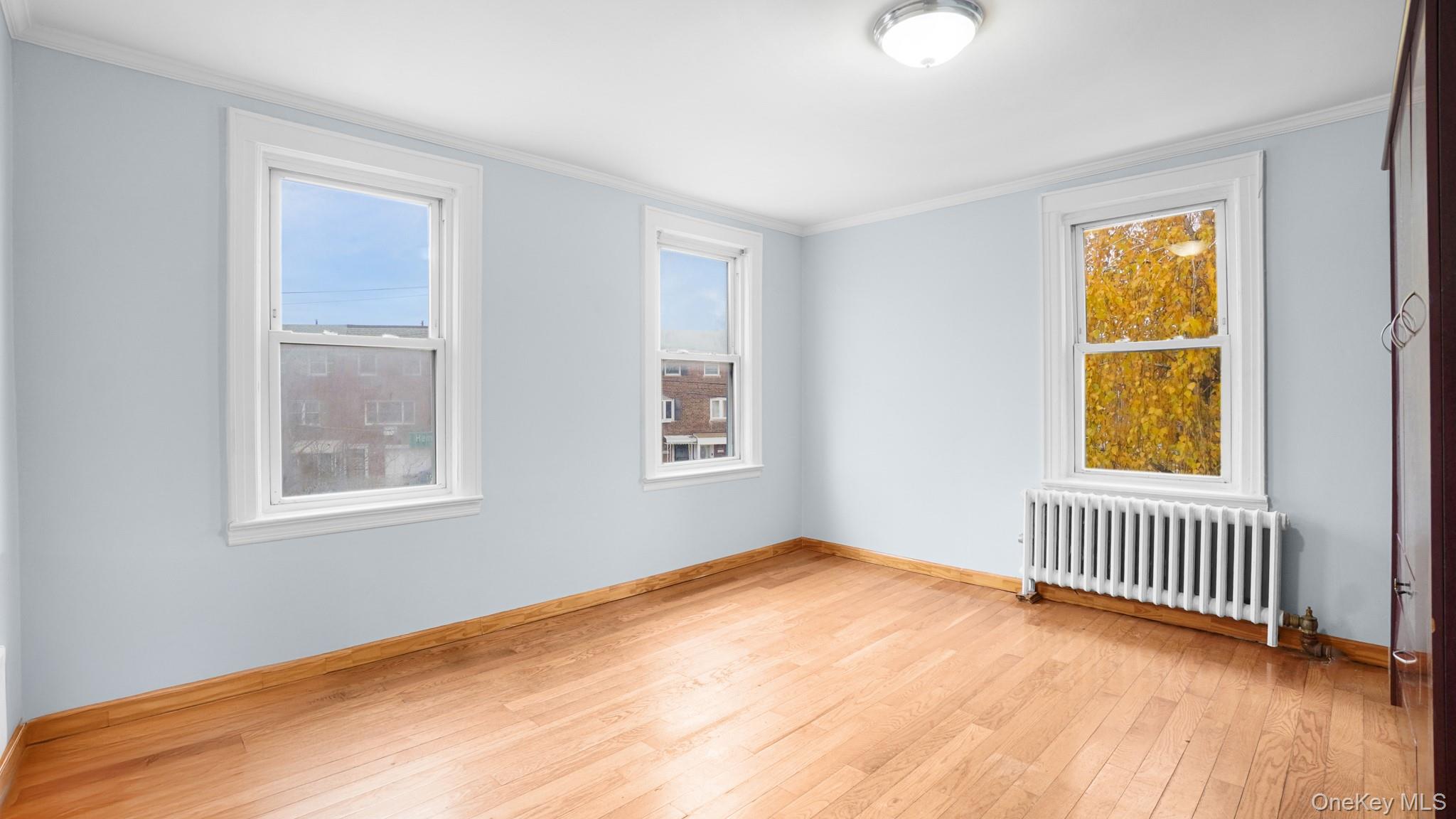 217-34 Hempstead Avenue Queens, NY 11429 - Photo 11 of 21 a view of an empty room with a window and wooden floor