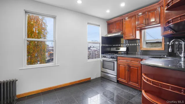a kitchen with stainless steel appliances granite countertop a stove a sink and a microwave
