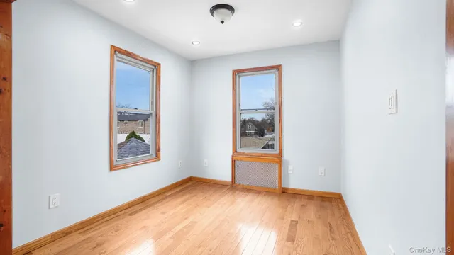 an empty room with window and wooden floor