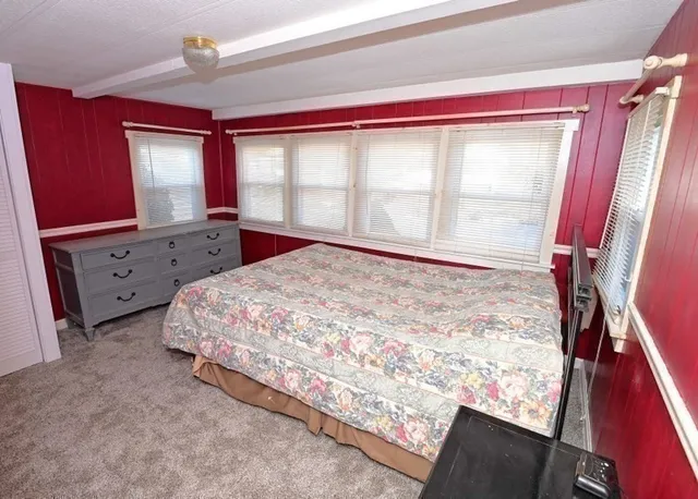 a large bed sitting in a bedroom next to a window