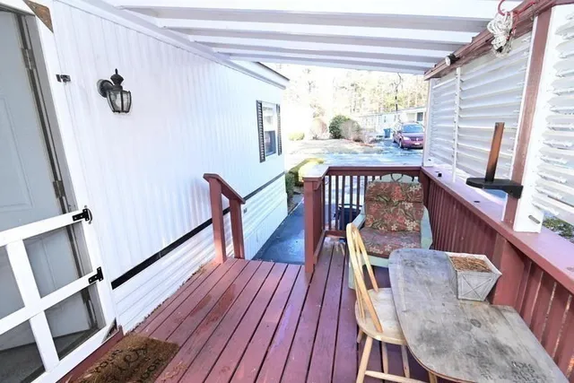 a view of a porch with wooden floor and furniture