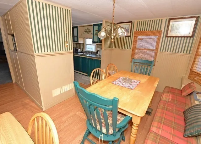 a dining room with furniture a chandelier and wooden floor