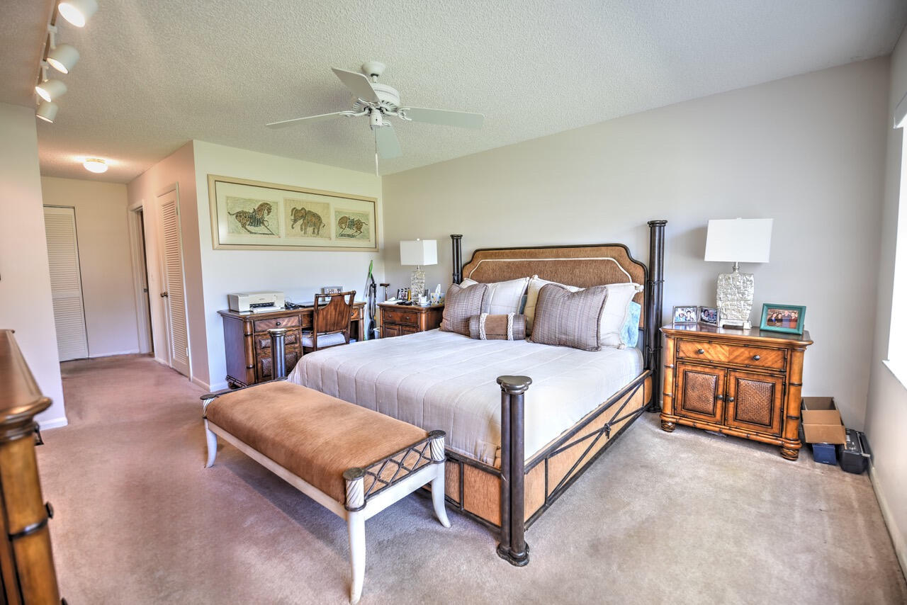 28 Stratford Lane West, Unit C Boynton Beach, FL 33436 - Photo 12 of 25 a bedroom with a large bed and a chandelier