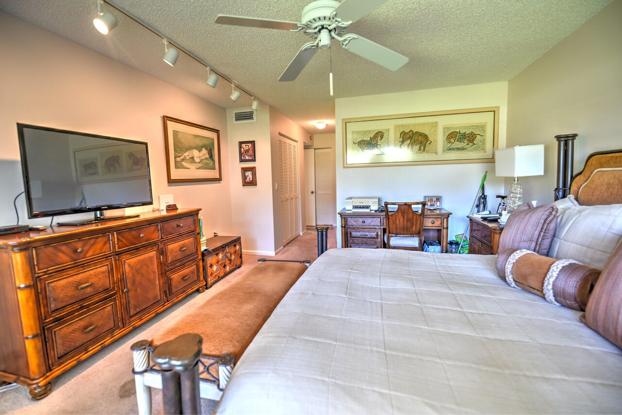 28 Stratford Lane West, Unit C Boynton Beach, FL 33436 - Photo 13 of 25 a bedroom with furniture and flat screen tv