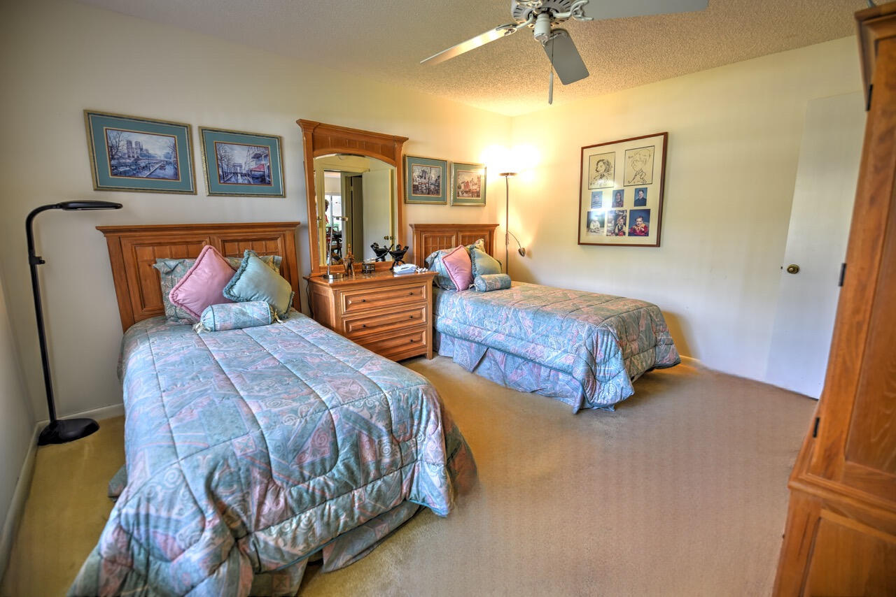 28 Stratford Lane West, Unit C Boynton Beach, FL 33436 - Photo 16 of 25 a bedroom with a large bed and a chandelier