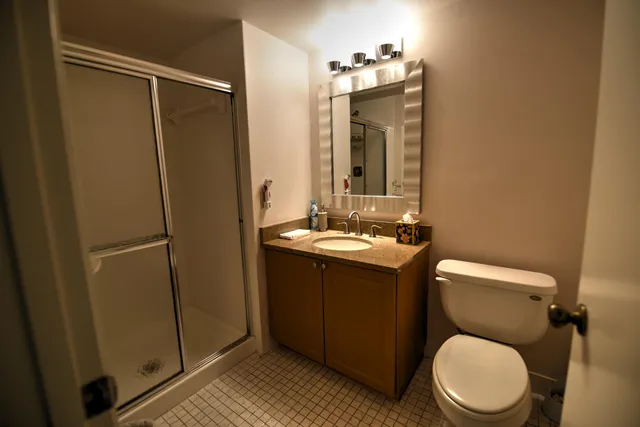 a bathroom with a toilet sink vanity and mirror
