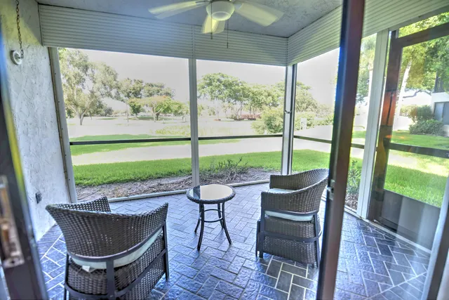 a living room with patio furniture and a floor to ceiling window