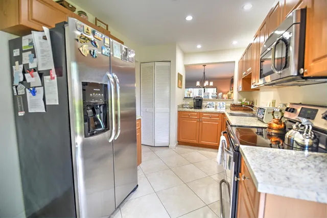 a kitchen with stainless steel appliances granite countertop a refrigerator and a sink