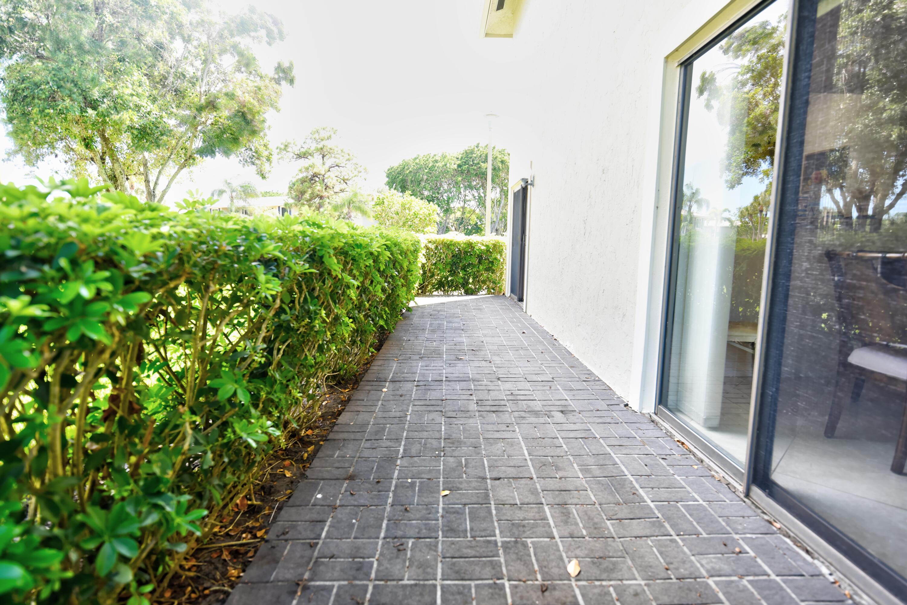 28 Stratford Lane West, Unit C Boynton Beach, FL 33436 - Photo 21 of 25 a view of a pathway with a yard