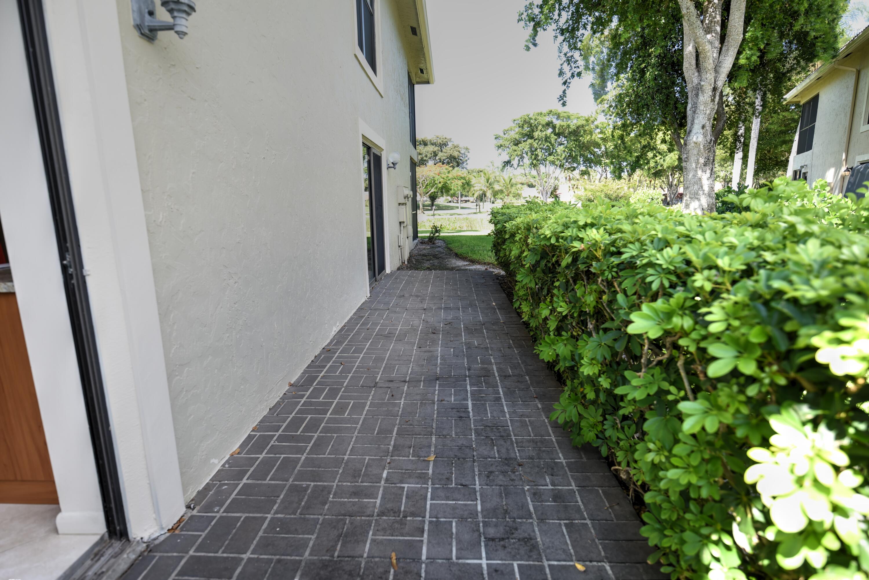 28 Stratford Lane West, Unit C Boynton Beach, FL 33436 - Photo 22 of 25 a view of a pathway both side of the house