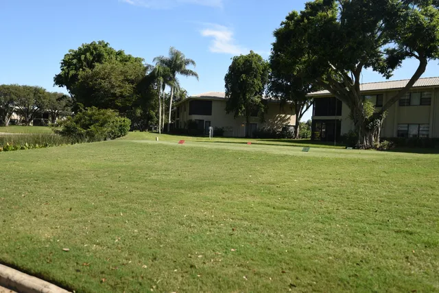 a brick house with a yard and palm trees