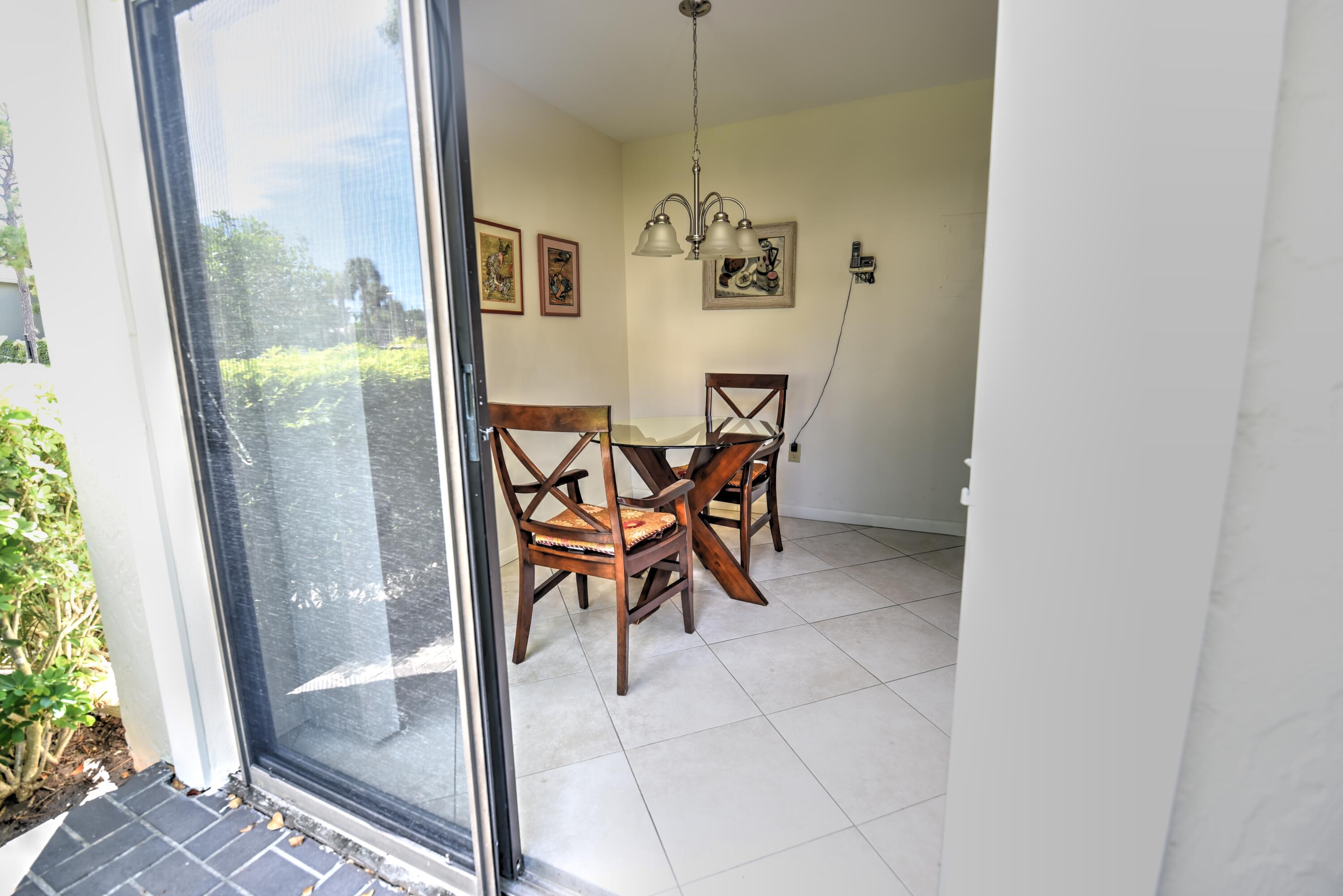 28 Stratford Lane West, Unit C Boynton Beach, FL 33436 - Photo 7 of 25 a view of a dining room with furniture and a window