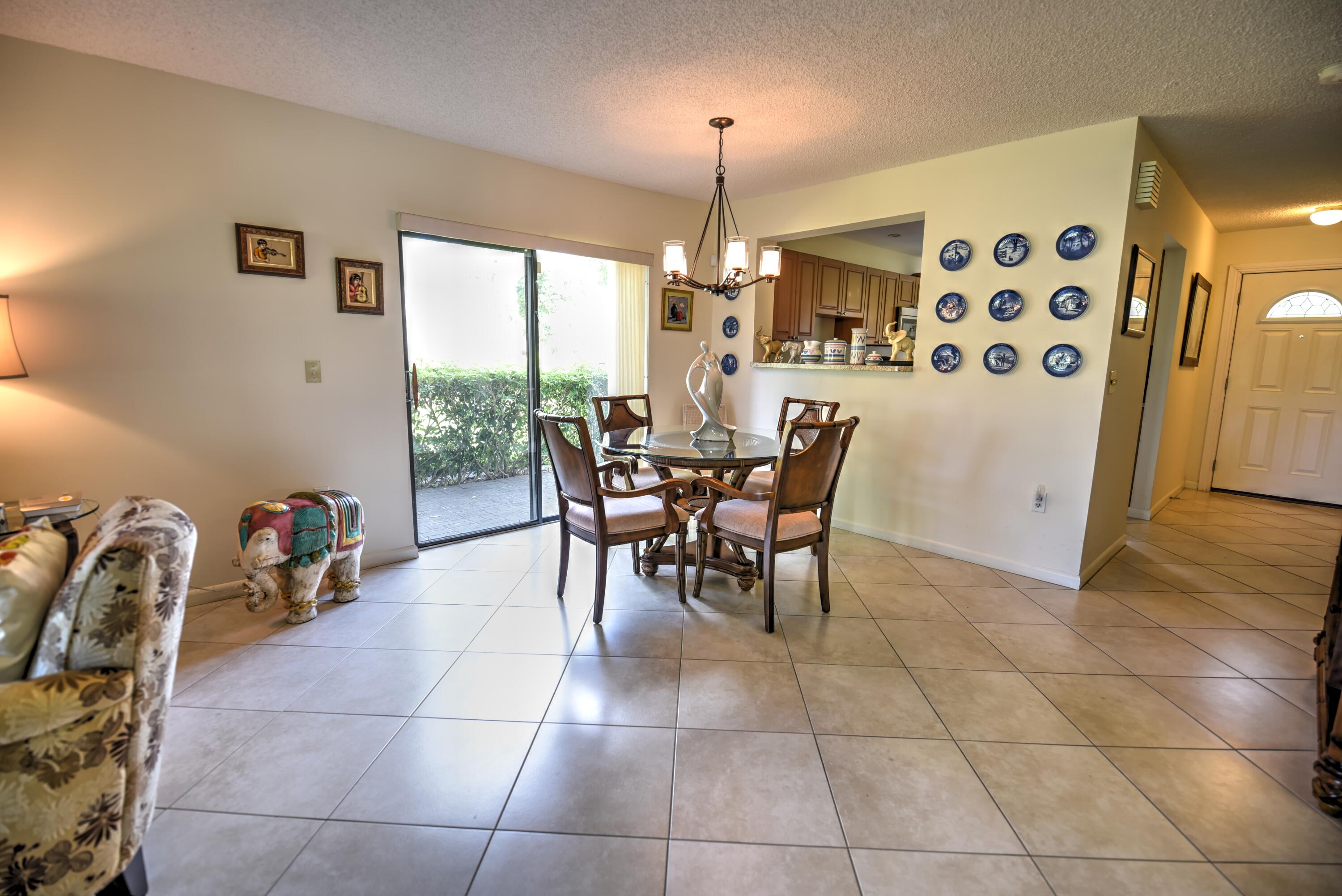 28 Stratford Lane West, Unit C Boynton Beach, FL 33436 - Photo 8 of 25 a dining room with furniture and a chandelier
