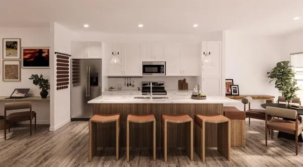 a kitchen with kitchen island a counter top a stove a sink a dining table and chairs