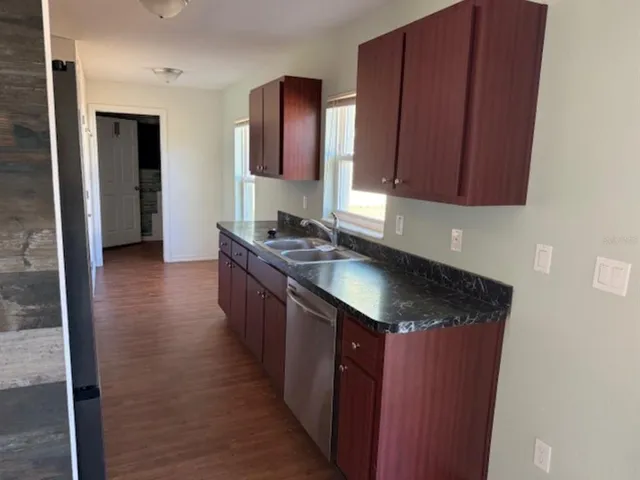 a kitchen with granite countertop a sink stove and cabinets