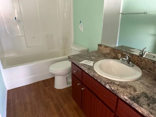 a bathroom with a granite countertop sink a toilet and a mirror