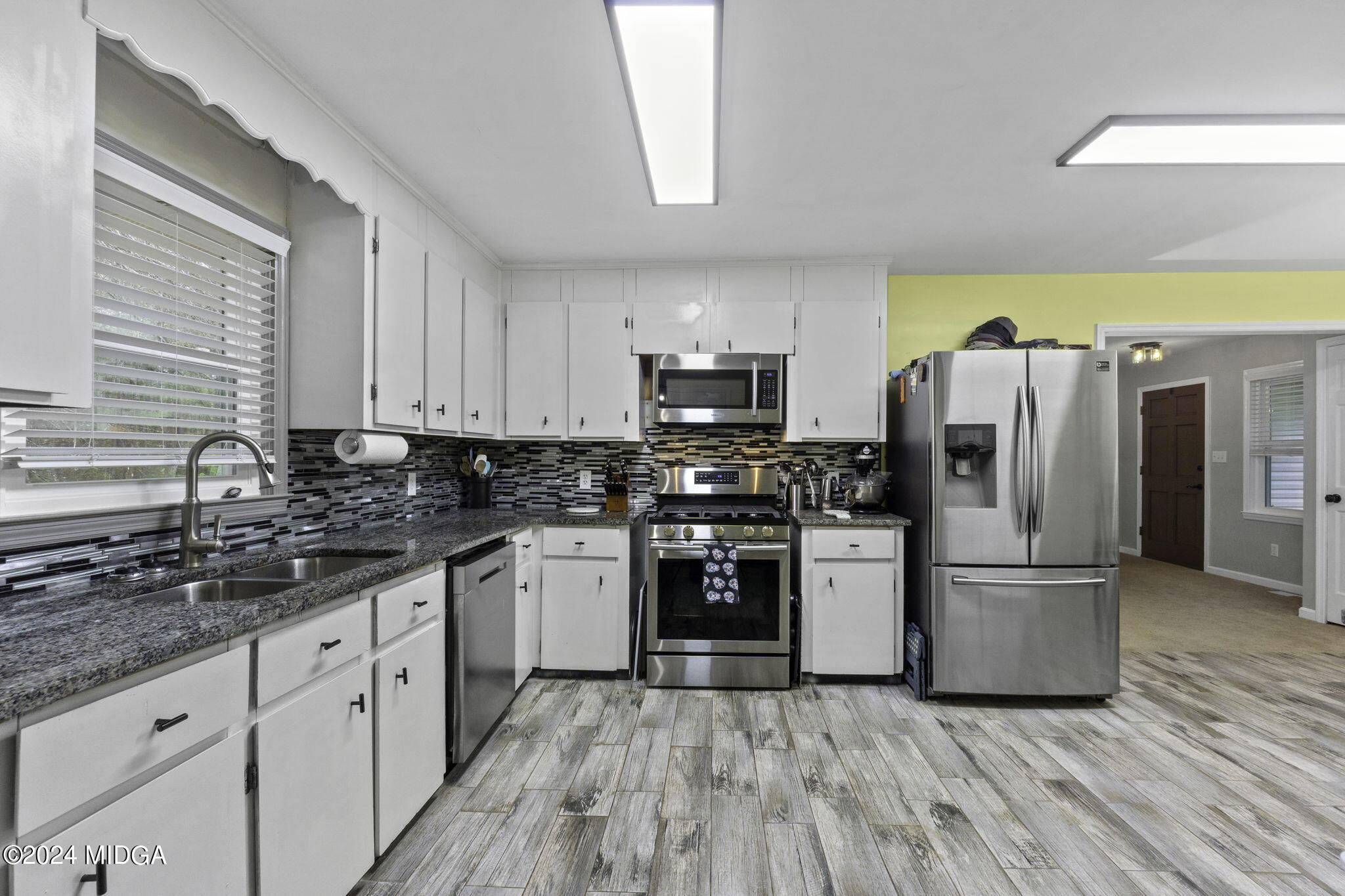 1299 Rainey Road Macon, GA 31220 - Photo 15 of 35 a kitchen with granite countertop a refrigerator and a stove top oven