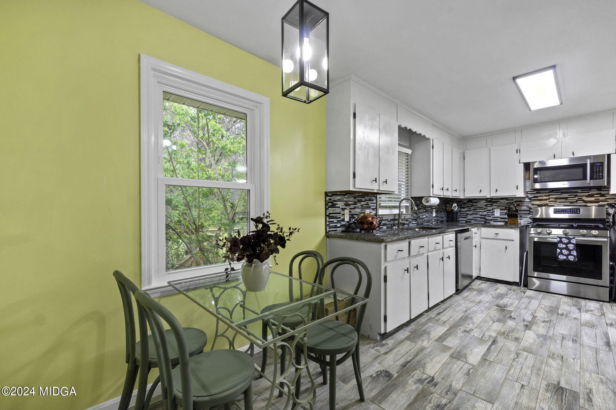 1299 Rainey Road Macon, GA 31220 - Photo 17 of 35 a kitchen with stainless steel appliances granite countertop a stove a sink dishwasher a microwave oven with a dining table and chairs