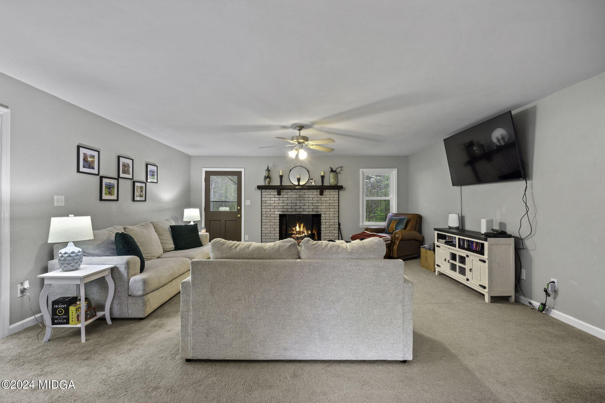 1299 Rainey Road Macon, GA 31220 - Photo 8 of 35 a living room with furniture a fireplace and a flat screen tv