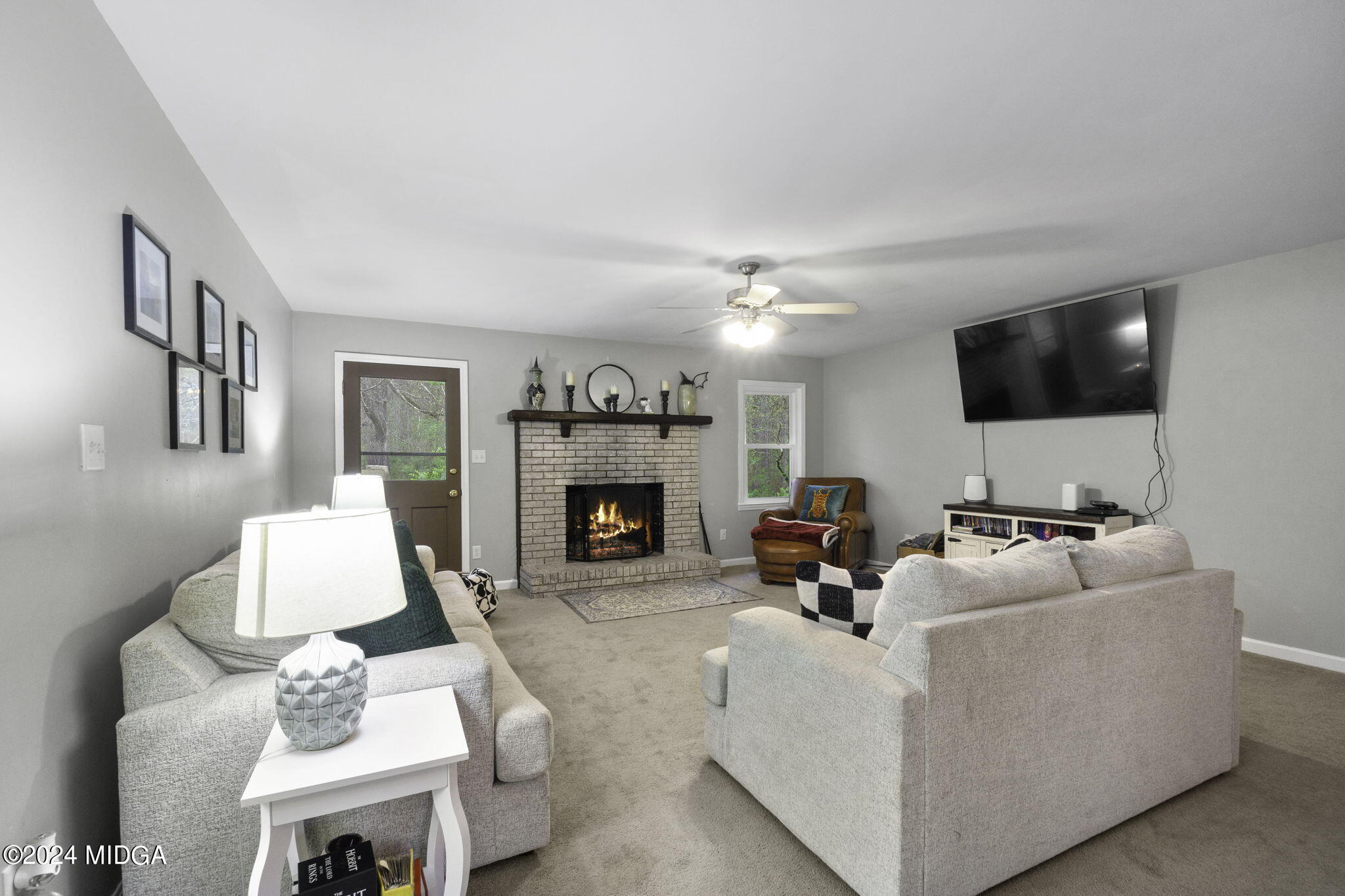 1299 Rainey Road Macon, GA 31220 - Photo 10 of 35 a living room with furniture a flat screen tv and a fireplace