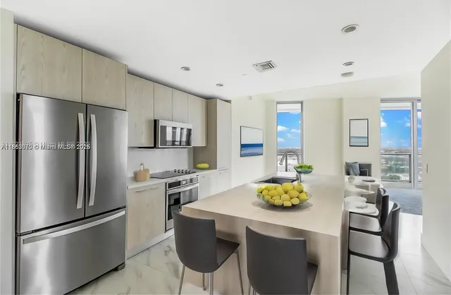 a kitchen with stainless steel appliances granite countertop a refrigerator and a stove top oven