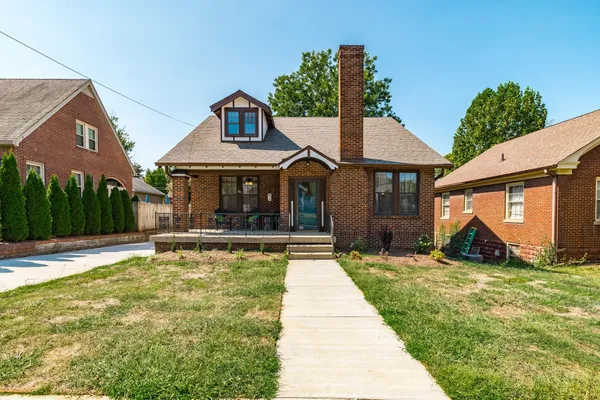 a view of a house with floor to ceiling windows and a yard