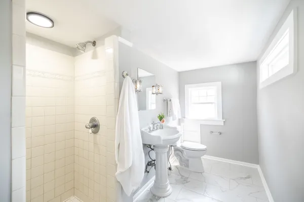 a bathroom with a granite countertop toilet sink and mirror