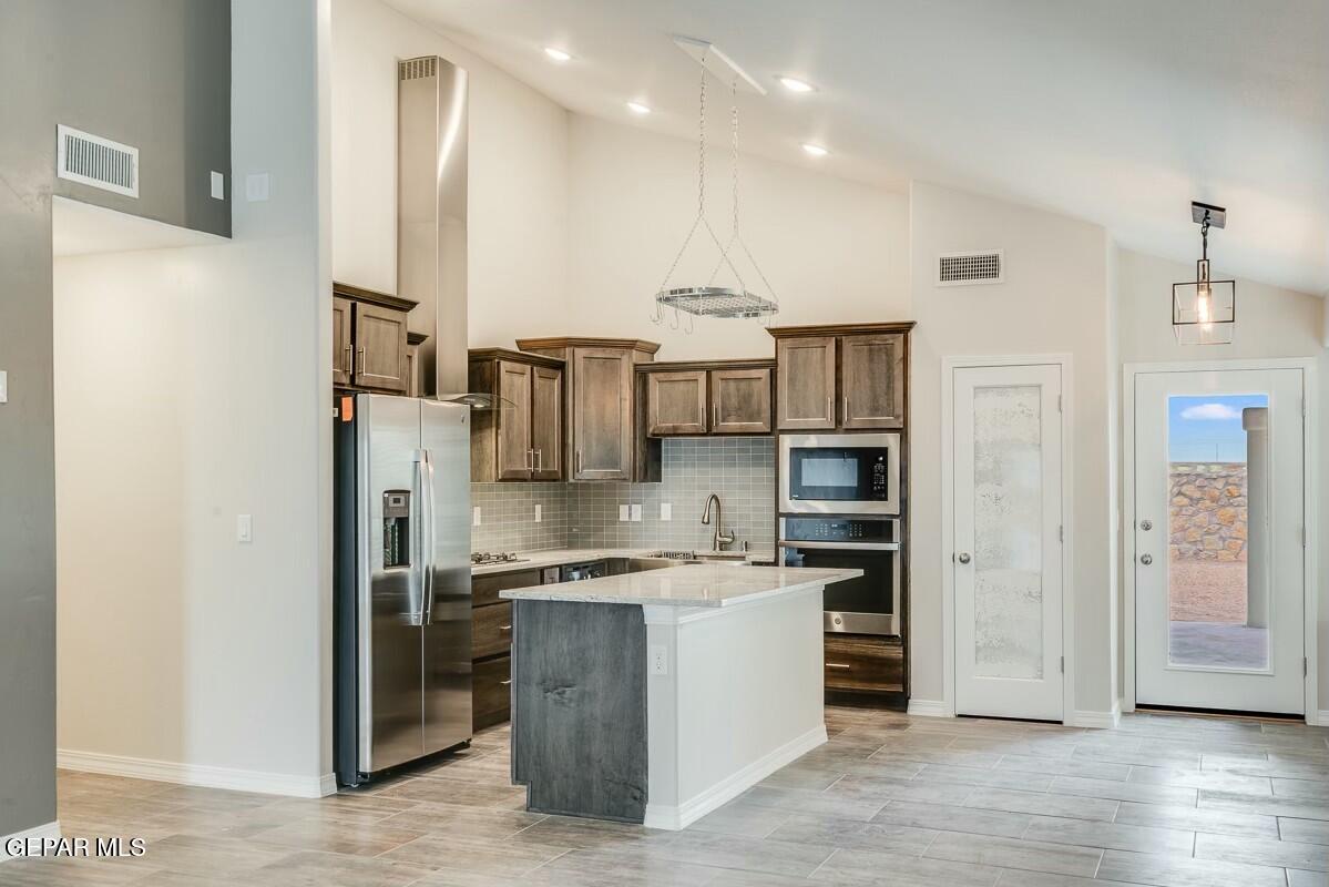 6064 Fall Ridge Street Sunland Park, NM 88008 - Photo 6 of 26 a kitchen with stainless steel appliances kitchen island granite countertop a refrigerator and a sink