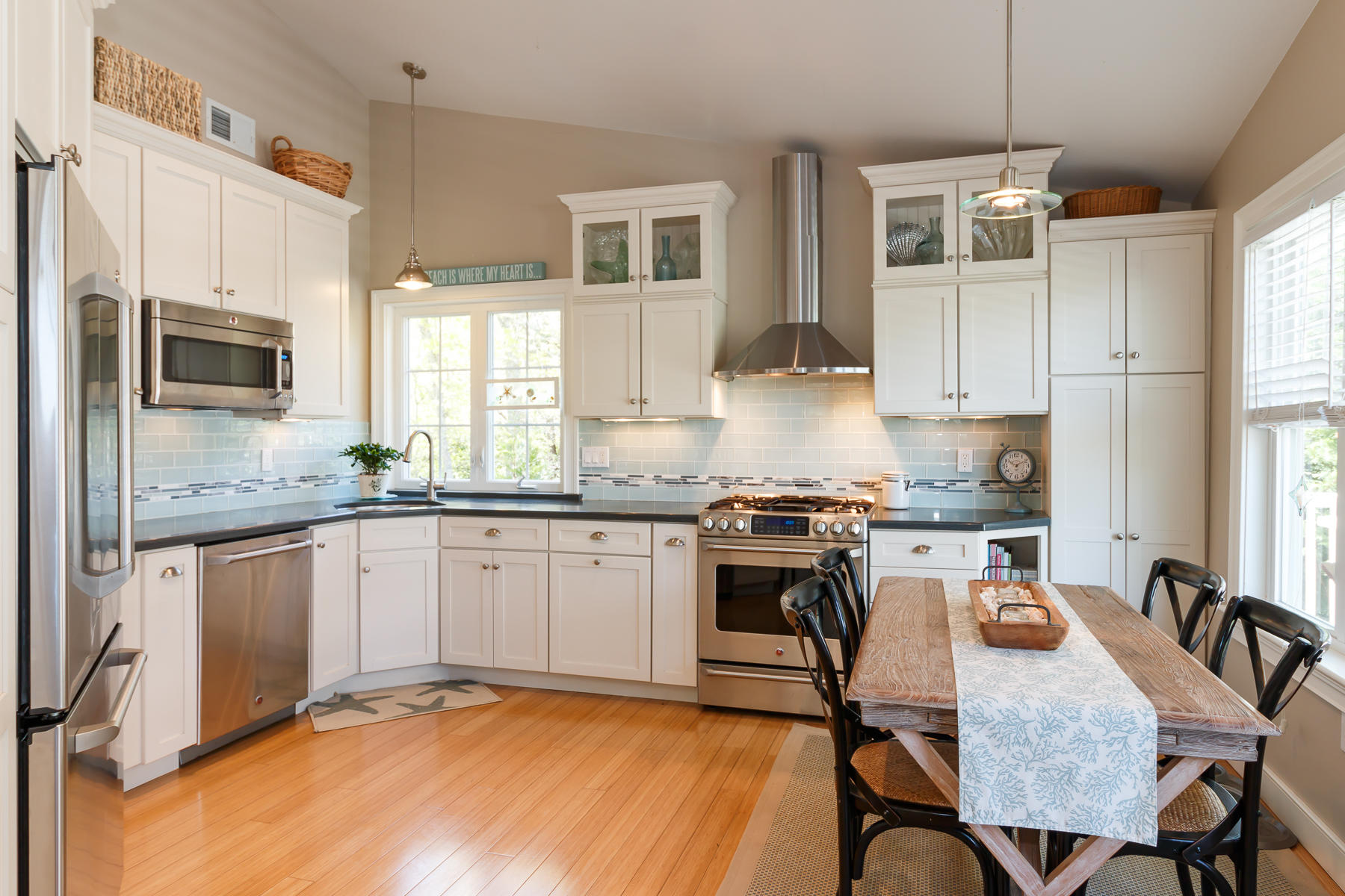 49 Old Shore Road Falmouth, MA 02540 - Photo 10 of 31 a kitchen with granite countertop a stove a sink a dining table and chairs